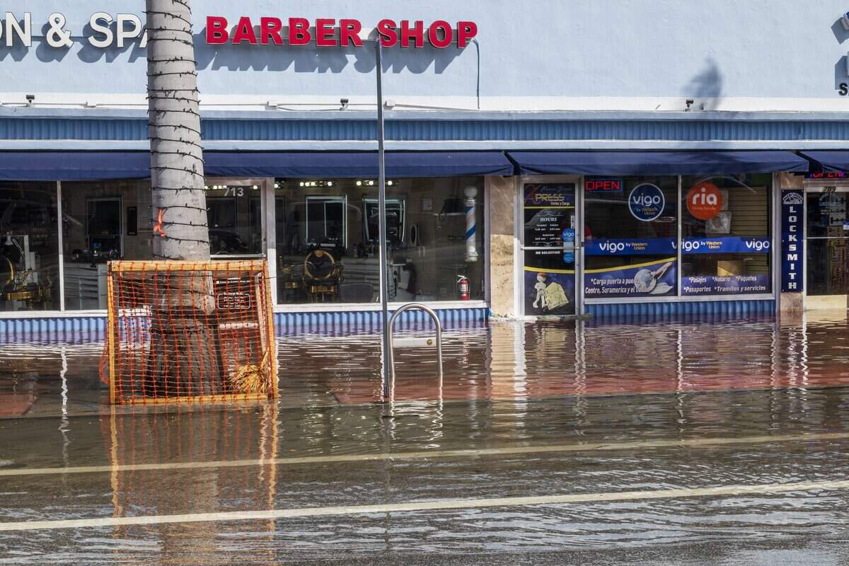Floodwaters cover sidewalks in front of businesses on 71st Street in Miami Beach during Tuesday’s king tide.