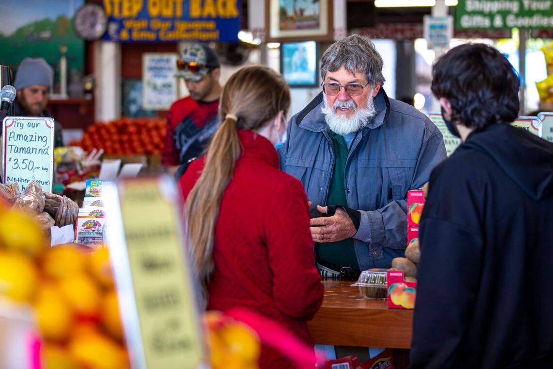 Owner and operator of Robert Is Here fruit stand, Robert Moehling, assists customers at the farmers market in Homestead on Sunday, Jan. 30, 2022. Crowds going to and from the Everglades packed the market for fruit and milkshakes.