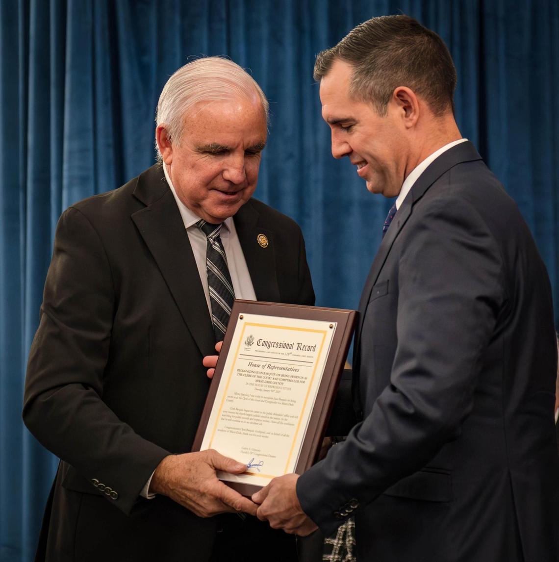 Congressman Carlos Gimenez presents Clerk Juan Fernandez-Barquin with a congressional record after Fernandez-Barquin was sworn in as clerk of court and comptroller of Miami-Dade County at the Stephen P. Clark Government Center in Miami on Jan. 10, 2025.