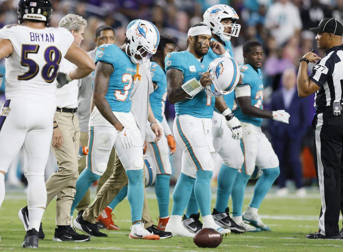 An injured Miami Dolphins running back Ollie Gordon II (31) walks off the field with teammates during the first half of an NFL football game against the Baltimore Ravens at Hard Rock Stadium on Thursday, October 30, 2025, in Miami Gardens, Florida.