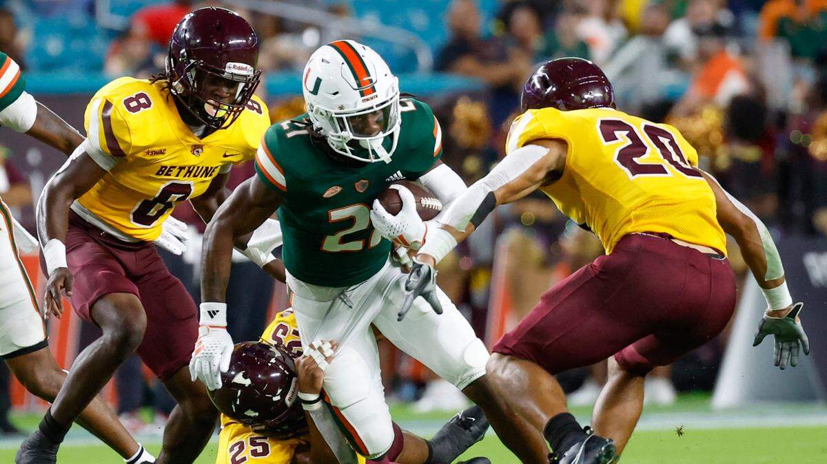 Miami Hurricanes running back Henry Parrish Jr. (21) runs for yardage as Bethune Cookman Wildcats linebacker Dearis Thomas (25) makes the tackle in the first quarter at Hard Rock Stadium in Miami Gardens, Florida on Thursday, September 14, 2023.