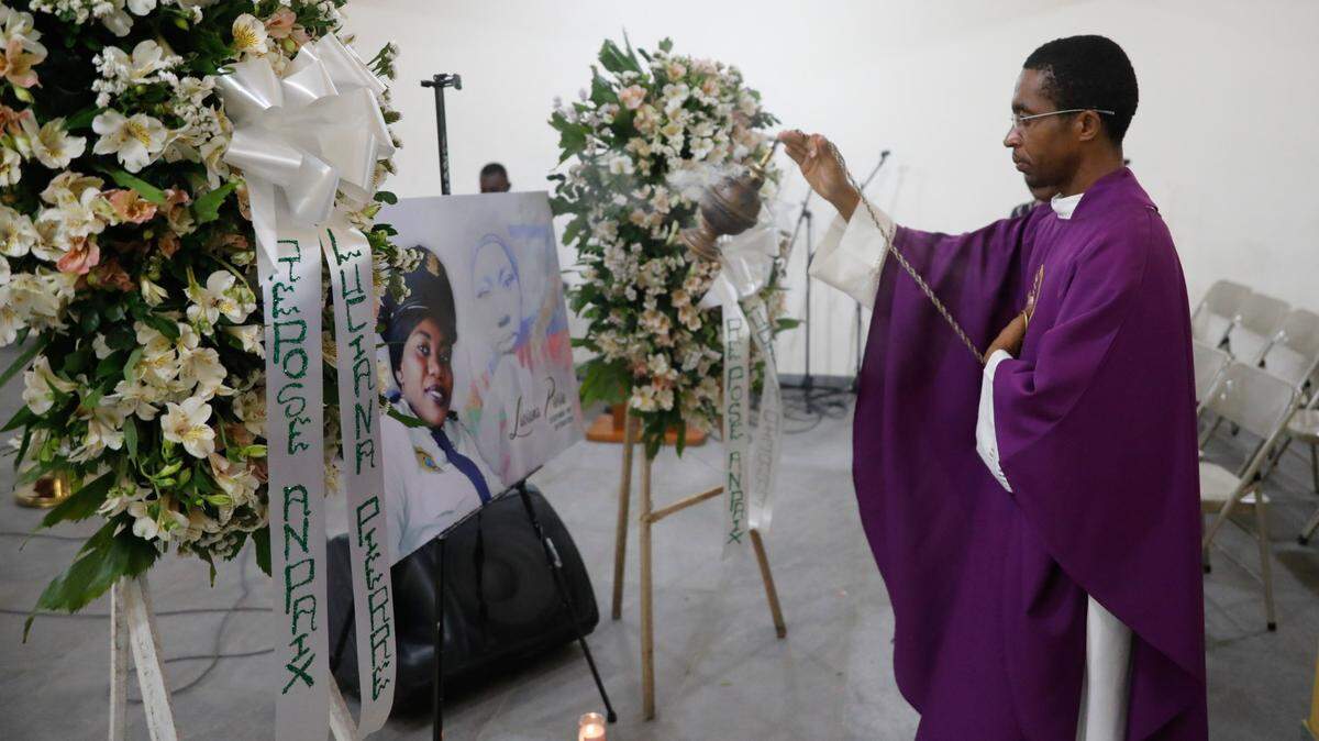 Un sacerdote agita incienso frente a una foto de la agente de policía Luciana Pierre durante su funeral en Puerto Príncipe, Haití, el martes 12 de marzo de 2024. Según la familia, Pierre fue asesinada en un ataque de pandillas armadas la semana anterior y su cuerpo no ha sido recuperado. (AP Photo/Odelyn Joseph)