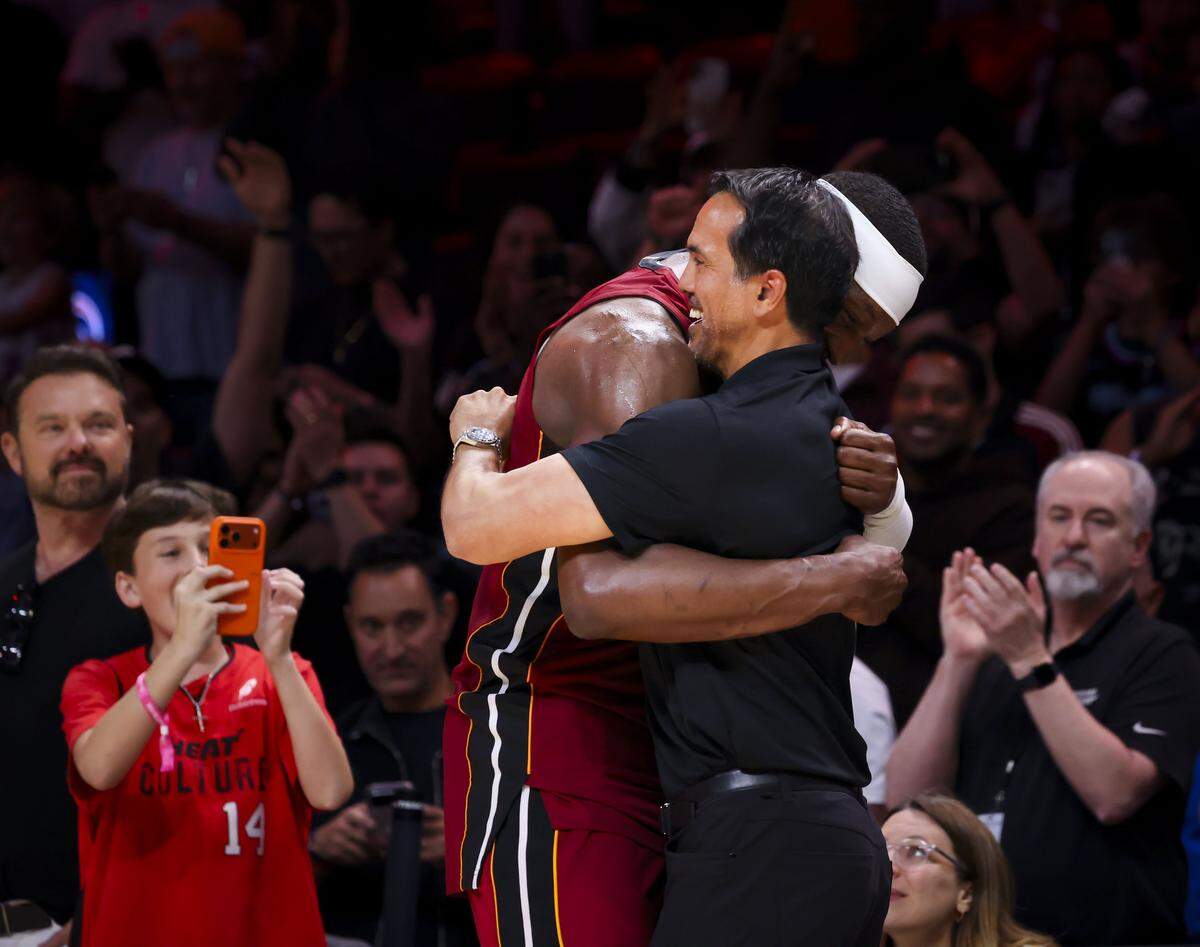 Miami Heat center Bam Adebayo (13) hugs head coach Erik Spoelstra during the second half of a basketball game after he scored 83 points against the Washington Wizards on March 10, 2026, at Kaseya Center in Miami.