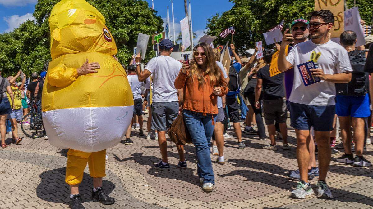 A person wearing an inflatable custom depicting President Donald Trump was among a group of protesters at the Miami-Torch of Friendship in downtown, Miami, during the ‘No Kings’ anti-Trump protests taking place nationwide and all across South Florida, on Saturday October 18, 2025.