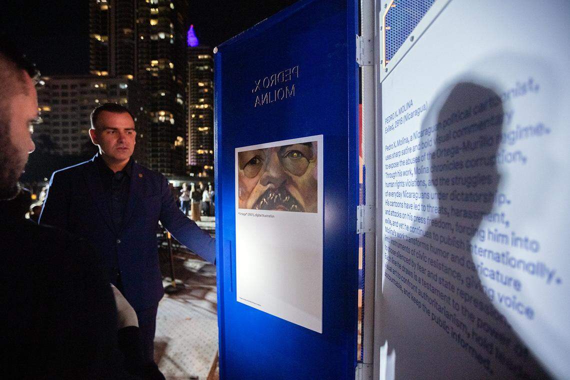 Miami Beach, Florida, December 1, 2025 - Miami Beach Commissioner, Alex Fernandez, center and Alian Collazo, executive Director of Cuban Freedom March, left, view a work by Nicaraguan Artist Pedro X. Molina during the unveiling of an installation titled Doors to Freedom. Doors to Freedom is public art installation that tells the stories of artists exposing authoritarian regimes. The installation will run from Dec. 1-7, 2025, at Art Week Miami Beach, during this year's Art Basel. Every artist featured in Doors to Freedom has been harassed, jailed, or exiled for refusing to remain silent. They are, The Gao Brothers (China), Luis Manuel Otero Alcántara (Cuba), Rayma Suprani (Venezuela), Song Byeok (Korea), Azza Abo Rebieh (Syria), Pedro X. Molina (Nicaragua), Zehra Dogan (Turkey) The installation was produced by the Human Rights Foundation (HRF), Cuban Freedom March (CFM), and sponsored by the City of Miami Beach.