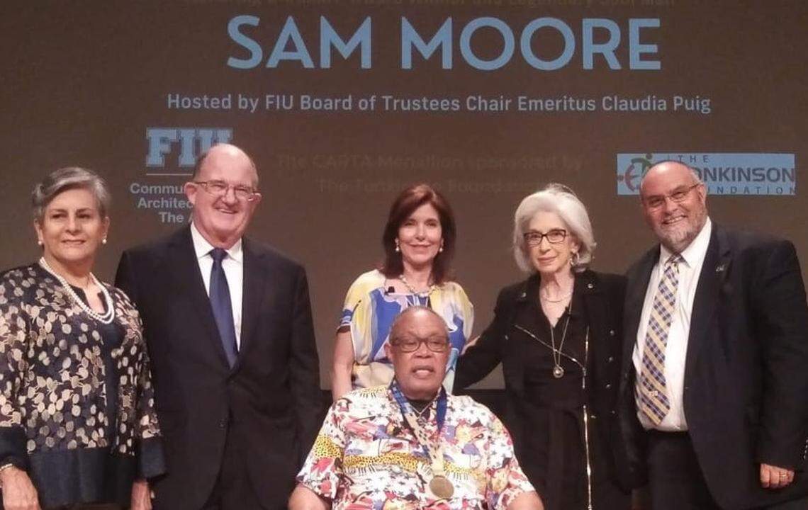 Music legend Sam Moore, front center, was honored as the inaugural recipient of the CARTA Medallion from the FIU College of Communication, Architecture + The Arts and the Tonkinson Foundation. The ceremony was at the Herbert and Nicole Wertheim School of Music & Performing Arts at Florida International University on May 19, 2022. Pictured with Moore: Margarita Tonkinson, left, with Rick Tonkinson, a member of the board of directors of the FIU Foundation and president of the Tonkinson Foundation; Claudia Puig, center back, FIU Board of Trustees chair emeritus; Joyce Moore; and Brian Schriner, right, dean of the FIU College of Communication, Architecture + The Arts.