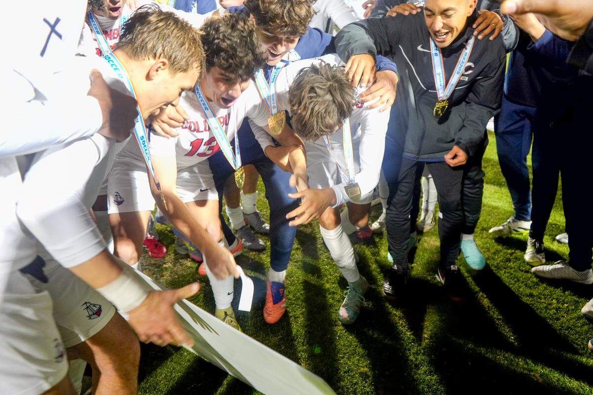 Columbus boys’ soccer players post their team’s name on the championship bracket after winning the Class 7A state title Wednesday at Spec Martin Stadium in DeLand, Fla.