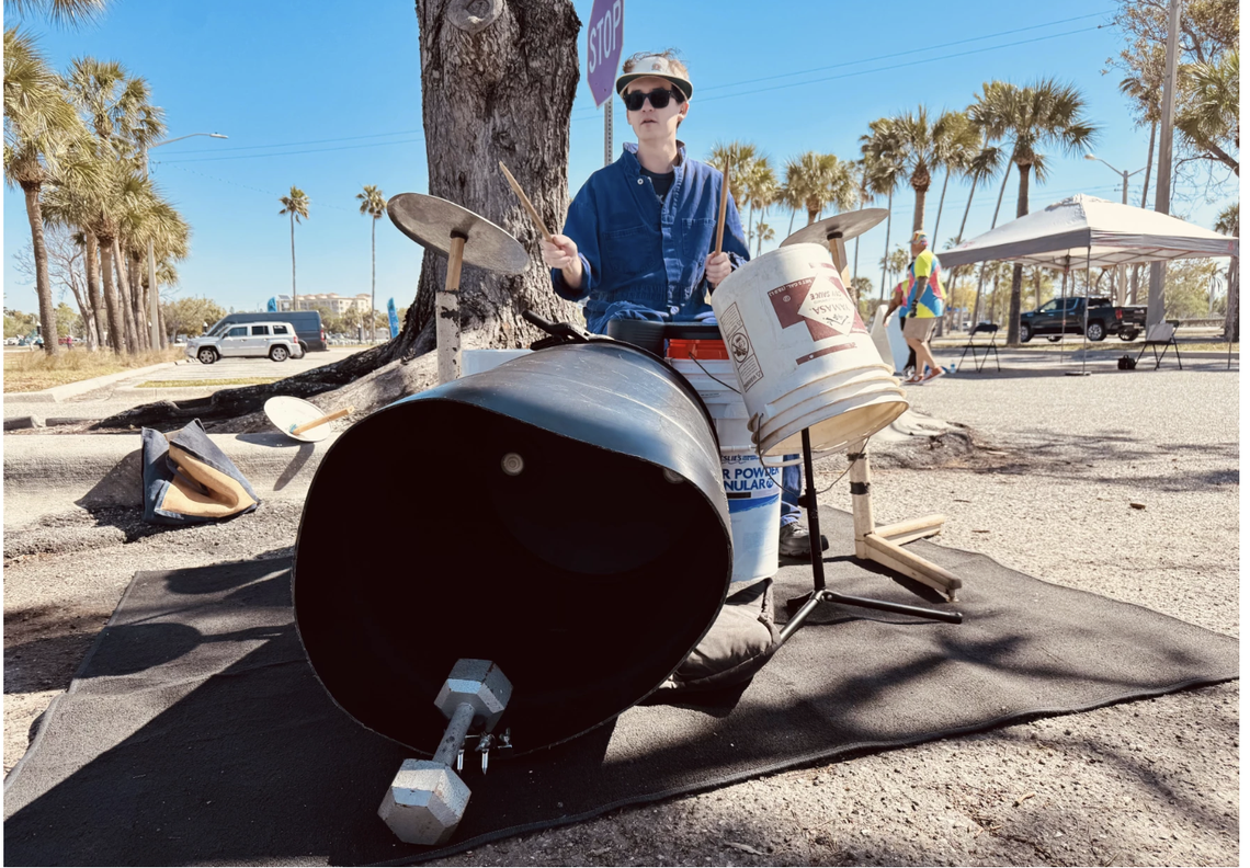 Wesley Backer keeps time for The Garbage-men on a drum set made with a barrel, buckets and sheet metal.
