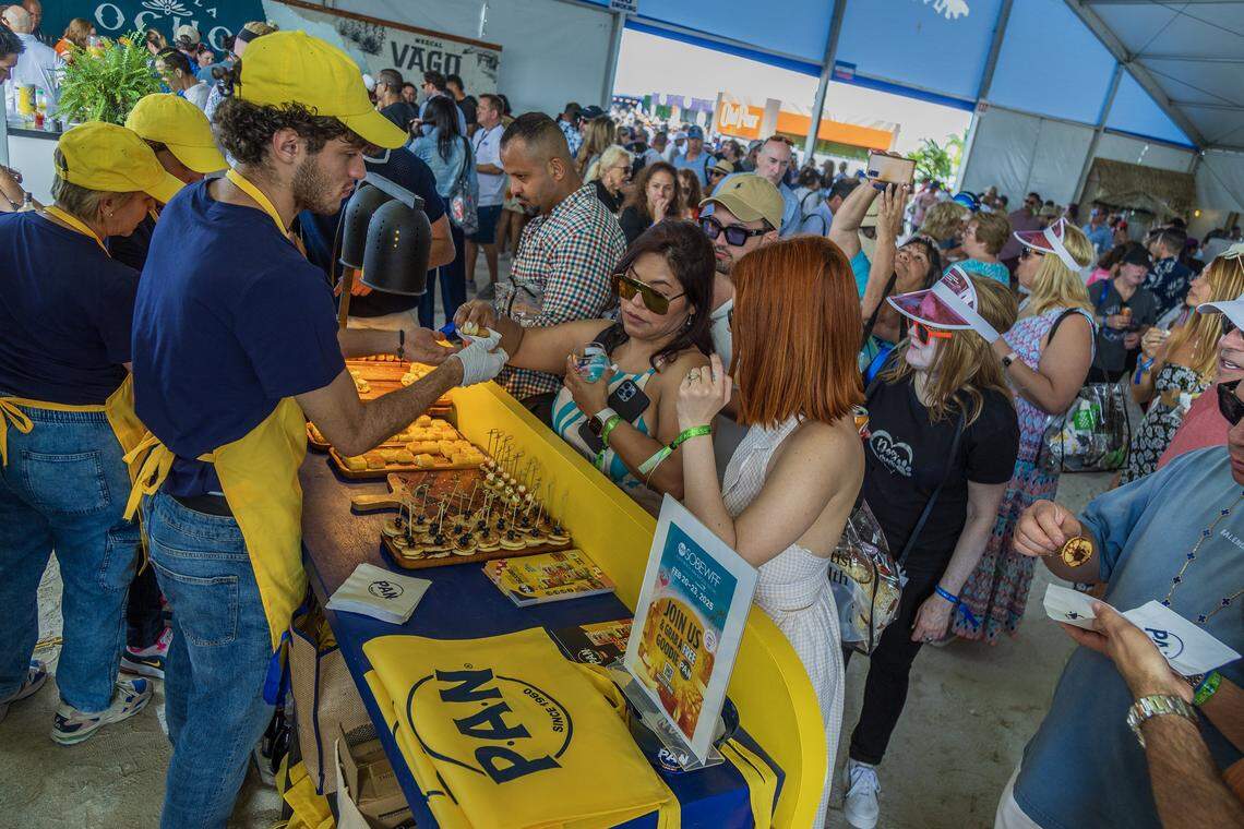 Gustavo Matheu serves bites of of mini arepas, mini cachapas, mini pancakes and Corn Bread were offered at the P.A.N. booth to attendees lining up at the PAN booth, during the Grand Tasting Village, SoBe Wine & Food Festival, in Miami Beach, on Saturday, February 22, 2025. 