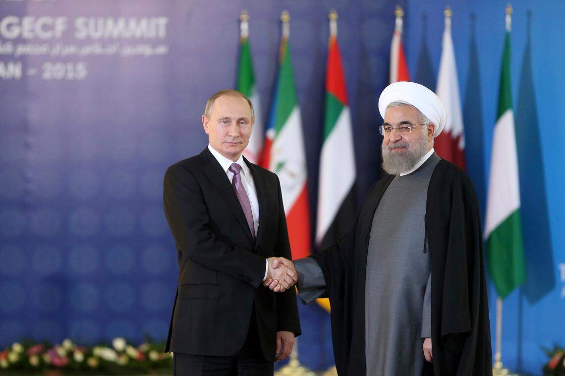 Russian President Vladimir Putin, left, shakes hands with his Iranian counterpart Hassan Rouhani at the Gas Exporting Countries Forum, GECF, summit meeting in Tehran, Iran, Monday, Nov. 23, 2015. (AP Photo/Ebrahim Noroozi)