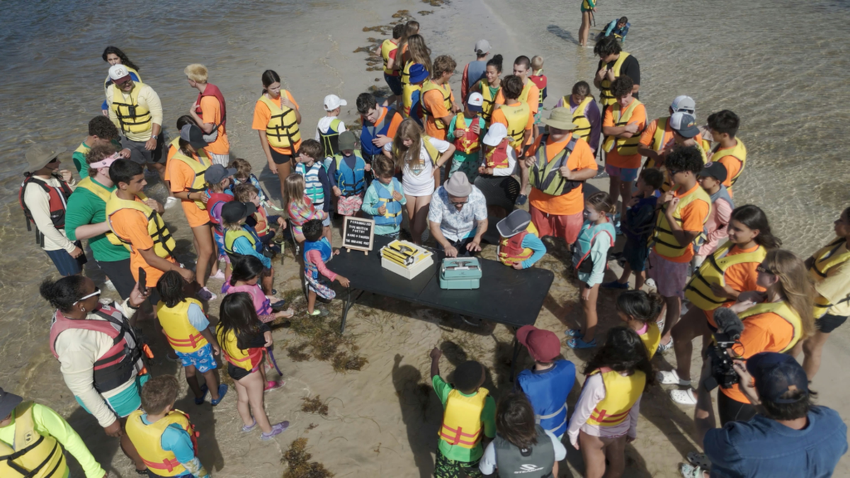 Poet Oscar Fuentes surrounded by kids from Shake-A-Leg Miami in a scene from “Poetry City.”