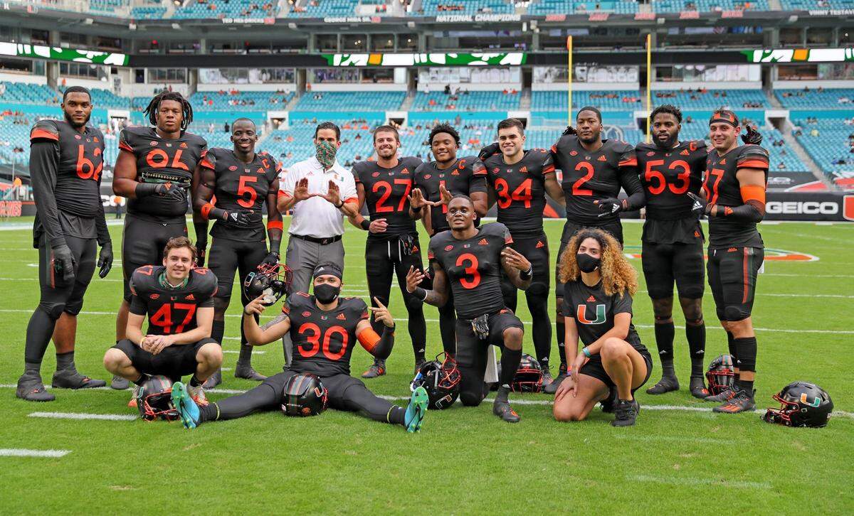 Canes’ coach Manny Diaz poses with the Miami Hurricanes football senior class players as they prepare to play the North Carolina Tar Heels at Hard Rock Stadium In Miami Gardens, Florida, Saturday, December 12, 2020.