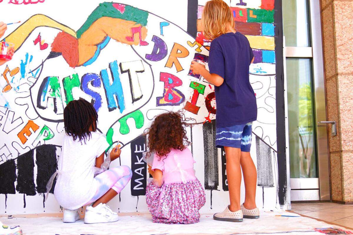 Participants at last year’s Art + Mind Day at the Arsht leave their mark on the Mind Day mural.