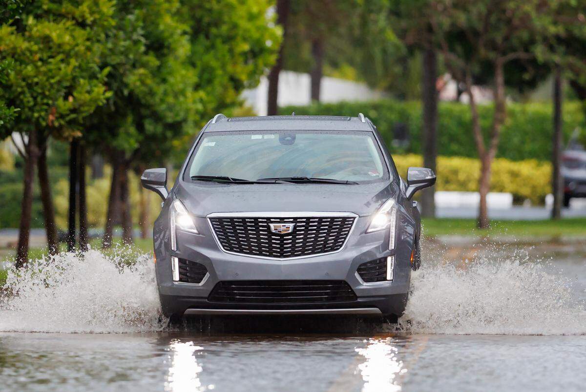 A car goes through a road flooded by heavy rains at North Bay Road in Sunny Isles Beach on Wednesday, April 25, 2023.