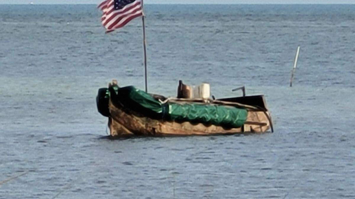 A makeshift boat with an American flag hoisted floats off the Florida Keys. It was one of several migrant vessels that came to the Keys Saturday and Sunday, April 2 and April 3, 2022.