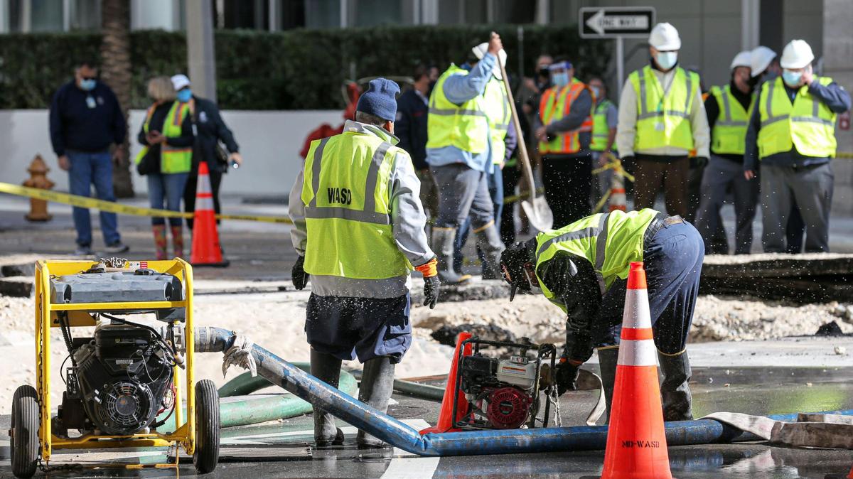 Miami-Dade County workers, including employees of the Water and Sewer Department photographed here from a December repair job, have new policies for when they can return to work after a COVID-19 diagnosis.