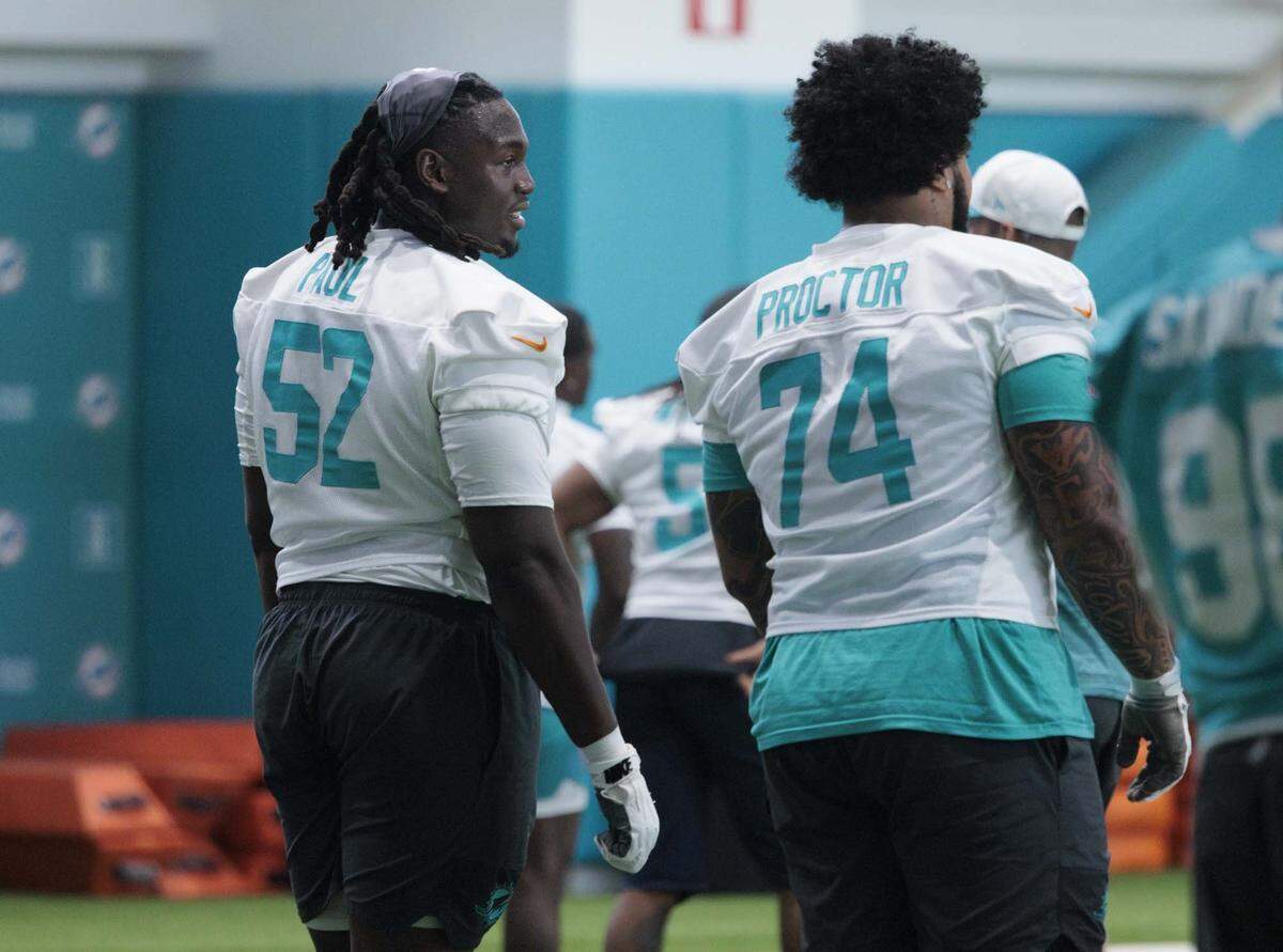 Offensive Lineman Patrick Paul (52) and Kadyn Proctor (74) talk during warmups at Miami Dolphins organized training activities on Tuesday, May 19, 2026, at Baptist Health Training Complex in Miami Gardens, Fla.