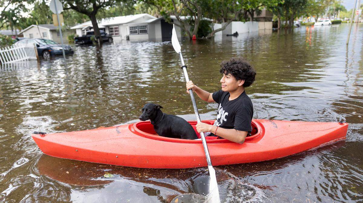 Stranahan High School student, Erick Martinez, 16, and his dog, Estrella, ride a kayak down a flooded street in his Edgewood neighborhood on Thursday, April 13, 2023, in Fort Lauderdale, Fla. A torrential downpour severely flooded streets partially submerging houses and cars across South Florida.