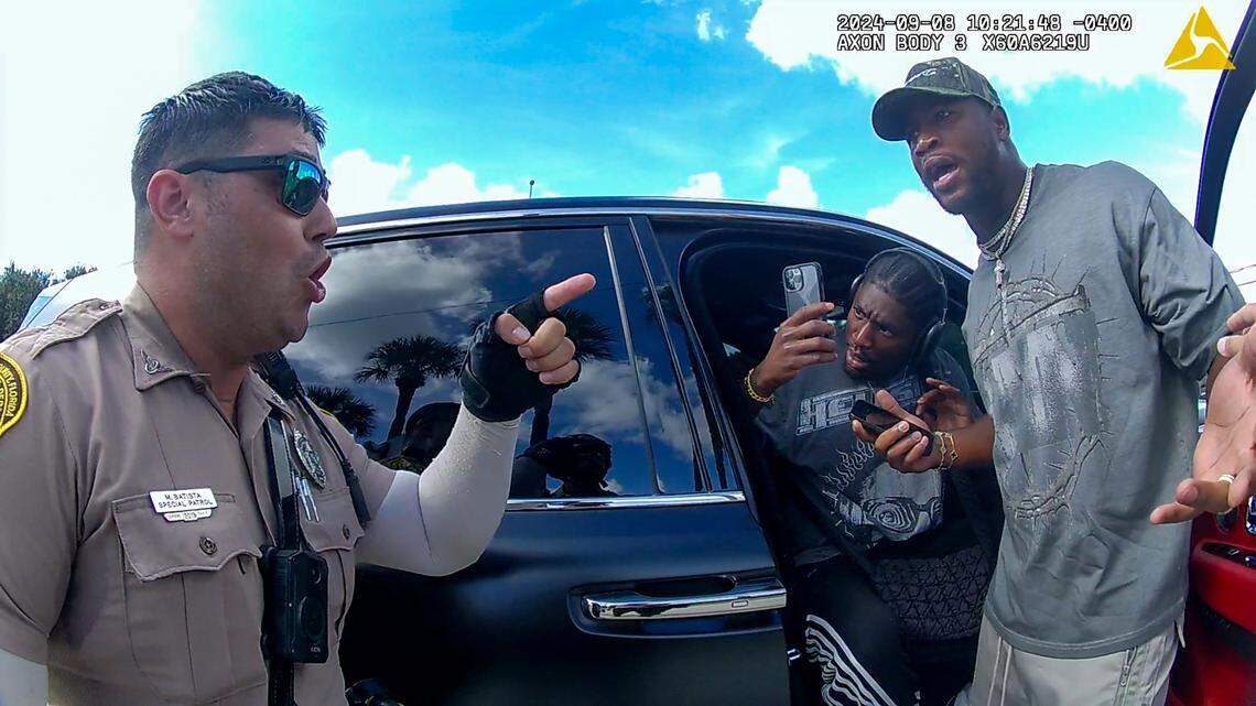 Miami-Dade police officer M. Batista orders Miami Dolphins tight end Jonnu Smith to leave the scene after police pulled over Dolphins’ star receiver Tyreek Hill for speeding by Hard Rock Stadium, on Sunday, Sept. 8, 2024.