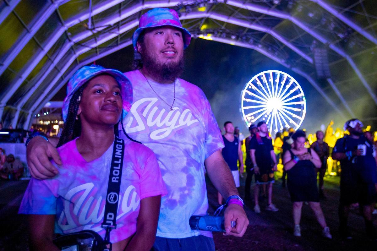Festival goers Alejandro Arias, right, and Davina Regis, left, react to a performance on the Monster stage during the second day of Rolling Loud Miami, an international hip-hop festival, at Hard Rock Stadium in Miami Gardens, Florida, on Saturday, July 23, 2022.