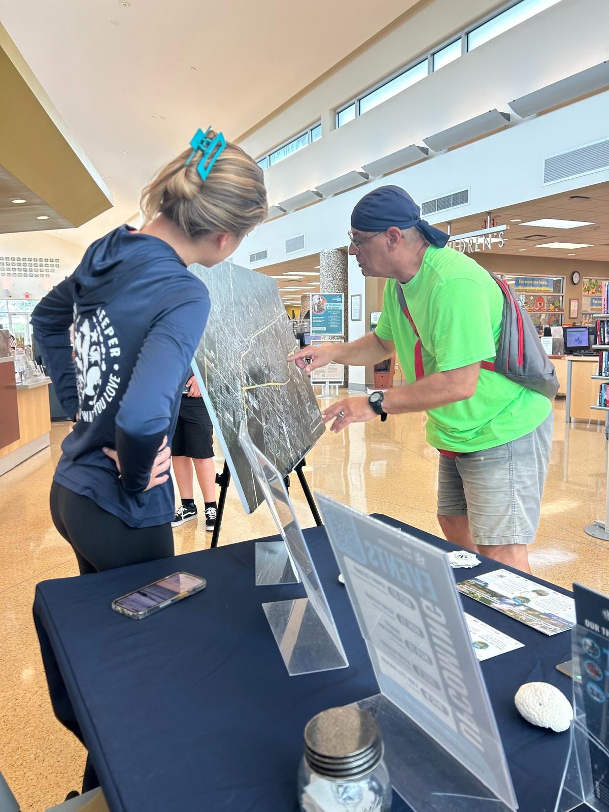 A staff member of Miami Waterkeeper talks to a community member about the new green infrastructure project, where neighbors can nominate eligible spaces in their community for potential nature-based upgrades.