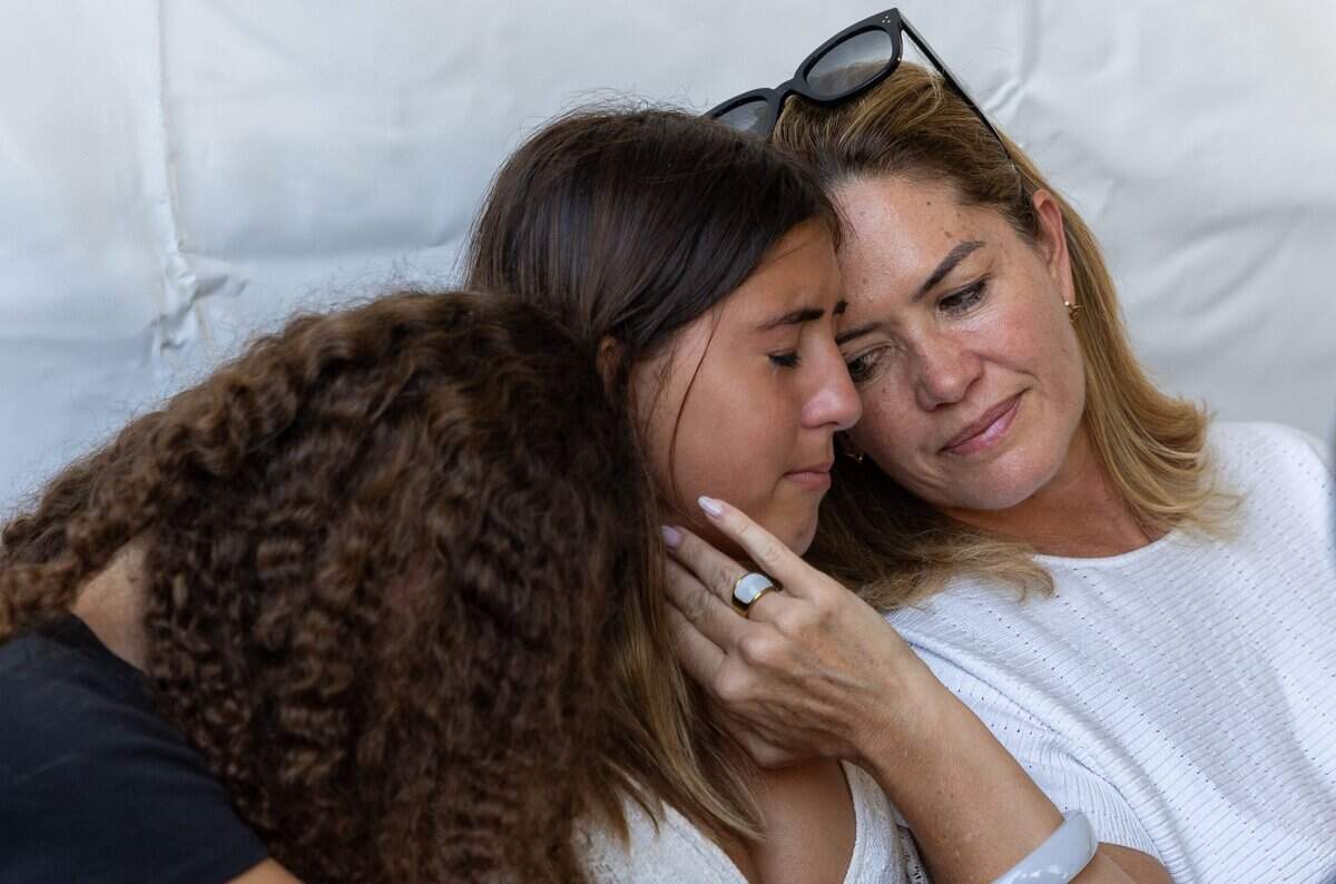 Isabella Cisternino, 15, center, cries as her mother, Tatiana Amaral, right, and friend Tayas Zamir, 15, left, comfort her during the fifth annual remembrance ceremony for the Champlain Towers South collapse in Surfside, Fla., on Wednesday, June 24, 2026.