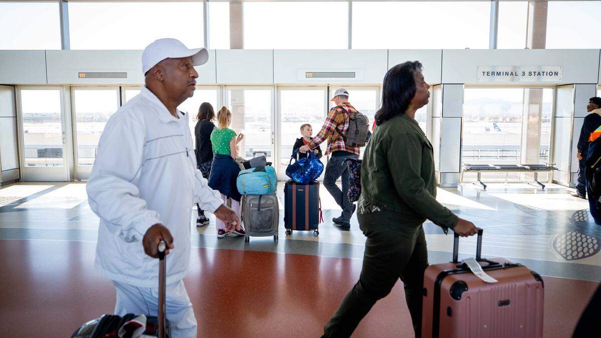 Travelers wait to board the PHX Sky Train at Sky Harbor International Airport in Phoenix on Nov. 21, 2023.