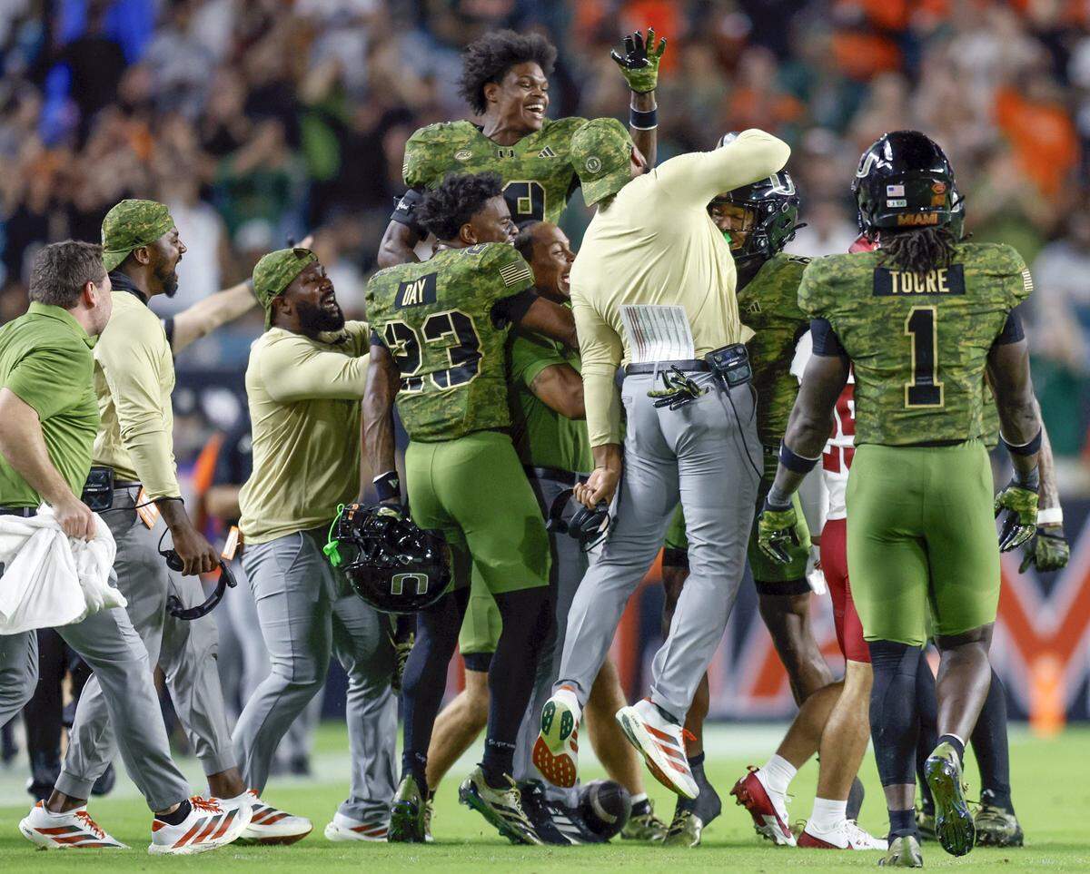Miami Hurricanes cornerback Xavier Lucas (6) celebrates with teammates after intercepting a Stanford Cardinal pass in the first half during their NCAA football game at Hard Rock Stadium in Miami Gardens, Florida, on Saturday, October 25, 2025.