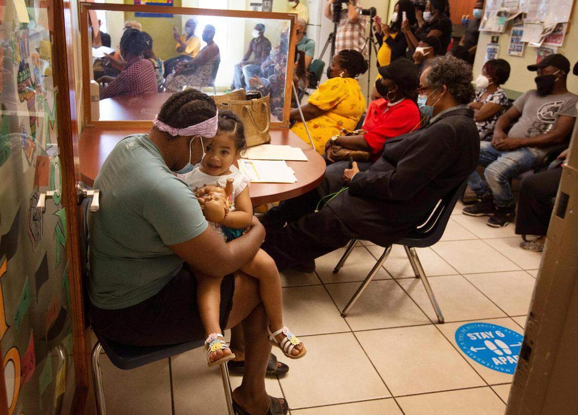 Julie Jean, an undocumented immigrant from Haiti, holds her 2-year-old daughter, Maria J. Tellez, in her lap as she listens to a press conference regarding the Biden administration’s redesignation of TPS for Haitians. Jean arrived in Miami in 2016, leaving behind her son in Haiti. Her son is now 14 and Jean said that she is hopeful that she will be able to get papers to see him and to bring him to Miami eventually. The Family Action Network Movement (FANM) held a press conference at its office in Little Haiti Monday, May 24, 2021, to applaud the Biden administration’s redesignation of TPS for Haitians that was announced on May 22.