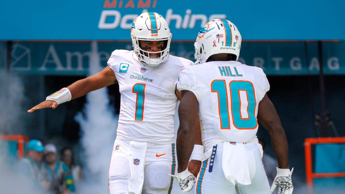 El quarterback de los Dolphins Tua Tagovailoa y el wide receiver Tyreek Hill (10) se saludan antes de enfrentar a los Patriots en el Hard Rock Stadium el domingo 11 de septiembre de 2022.