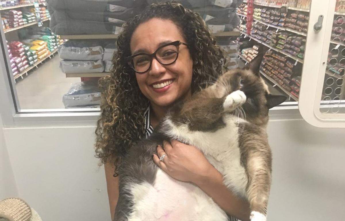 Amy, a 35-pound Siamese cat, is a lovable load for Lorna Mejia, an assistant director and live release program chief at Miami-Dade Animal Services, where Amy was surrendered by her previous owner.