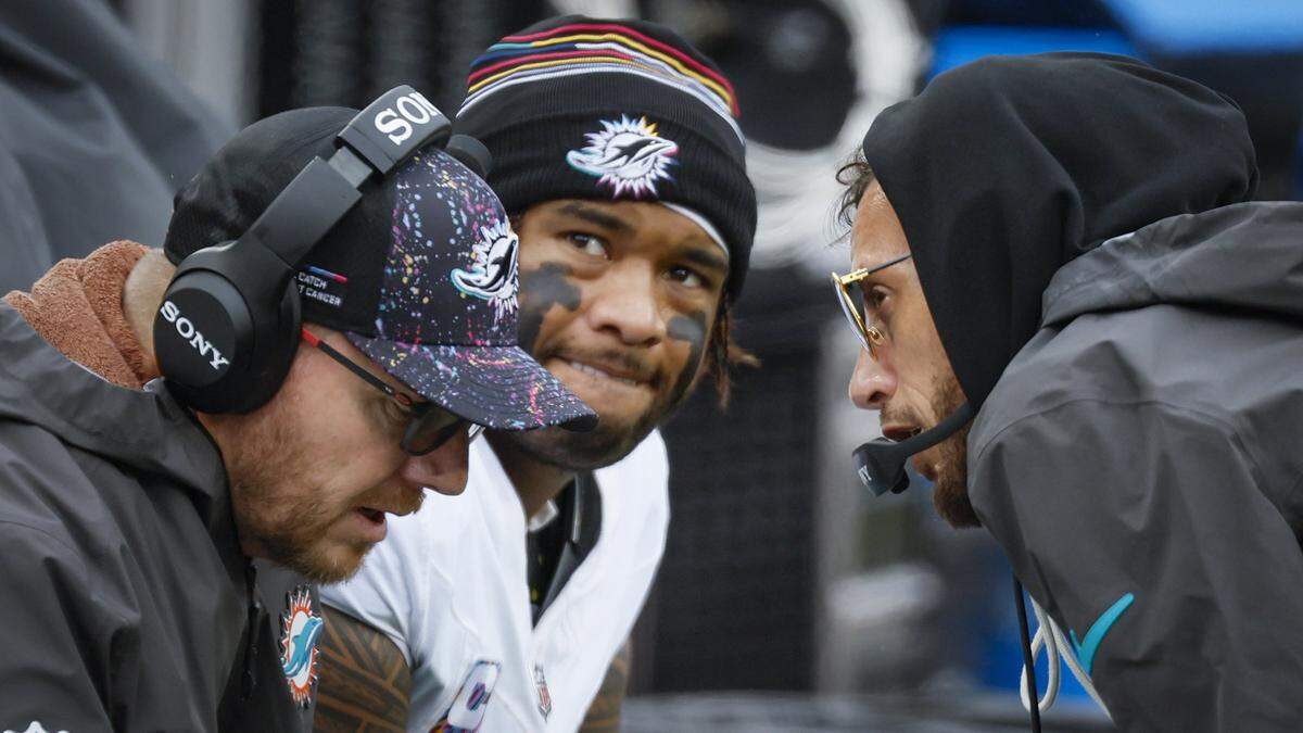 Miami Dolphins Head Coach Mike McDaniel, at right, talks with Miami Dolphins Quarterbacks / Pass Game Coordinator Darrell Bevell as quarterback Tua Tagovailoa (1) looks towards the score board late in the second half of an NFL football game at Huntington Bank Field in Cleveland, Ohio, on Sunday, October 19, 2025.