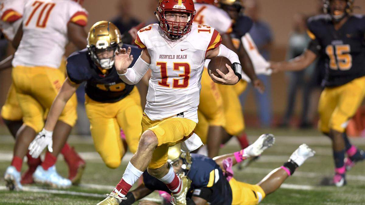 Deerfield Beach quarterback Michael Pratt runs for a first down against the St. Thomas Aquinas defense during the first half of their game, Friday, October 18, 2019.