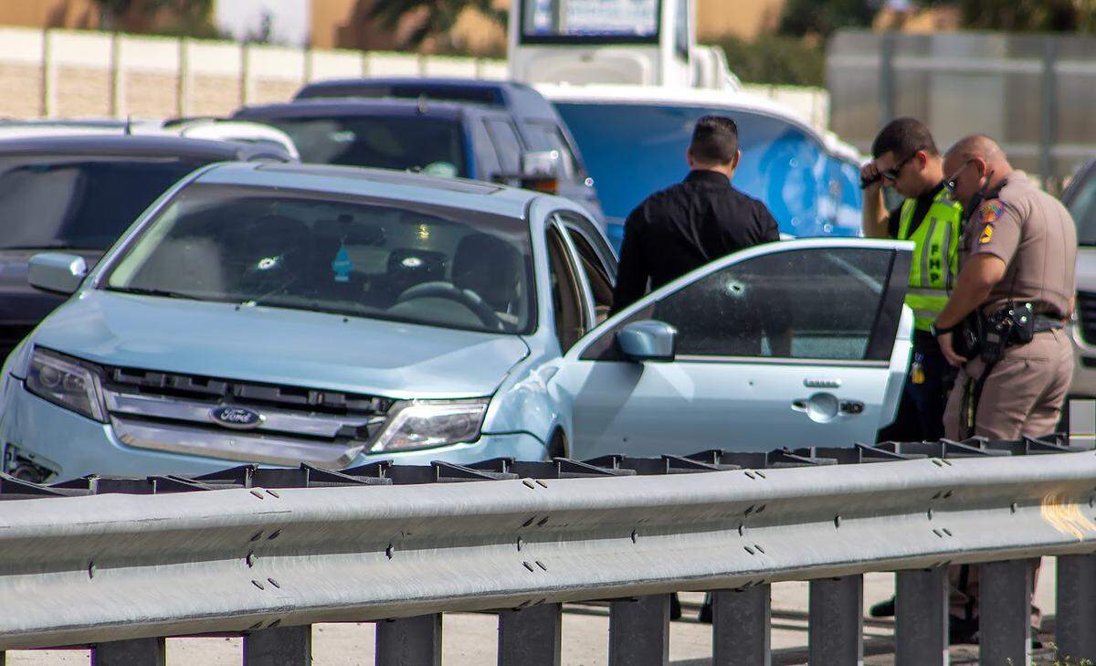 Florida Highway Patrol investigators look over a bullet-riddled blue Ford Fusion on the side of Florida’s Turnpike at the Campbell Drive exit near Homestead Friday morning, March 1, 2024.