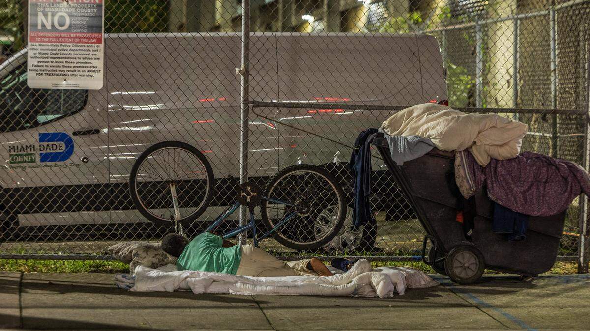 A homeless man sleeps on the sidewalk at NW 2nd Street in downtown Miami, during the Miami-Dade County's annual Point-in-Time (PIT) Homeless summer census of those experiencing homelessness from Homestead to Miami Beach to North Miami, conducted by members of the Miami-Dade Homeless Trust and the City of Miami Outreach Specialists, on Thursday, August 21, 2025.