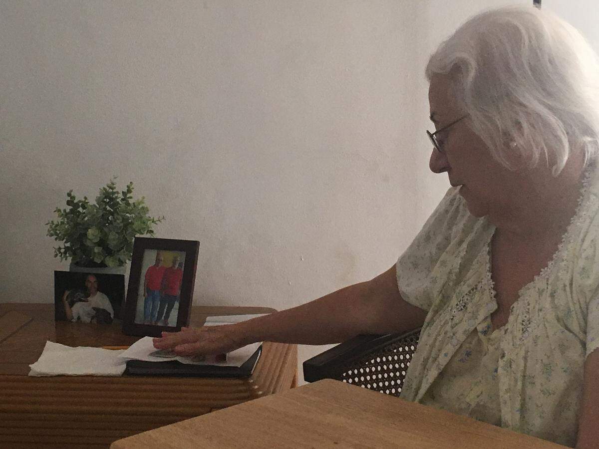 Pilar Humet looks at photos of her son Jaime Dec. 19, 2018. Jaime Humet was murdered Dec. 10, 2018, when he stopped at a Miami Gardens ATM. Police are still looking for his killer.