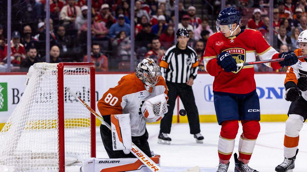 Philadelphia Flyers goaltender Dan Vladar (80) stops a shot as Florida Panthers center Anton Lundell (15) looks on during the first period of an NHL game at Amerant Bank Arena on Thursday, October 9, 2025, in Sunrise, Fla.