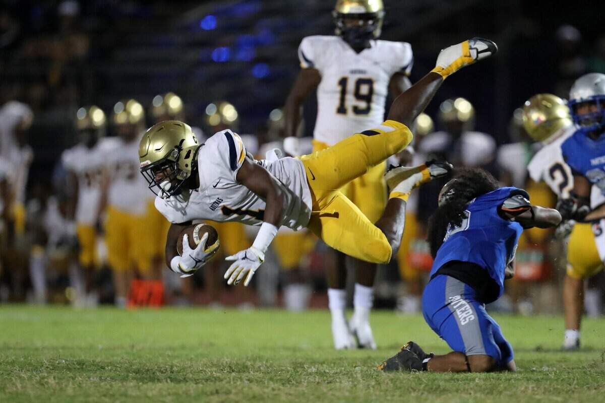 St. Thomas Aquinas defensive back King Mack is tripped up by Dillard running back Jordan Reeds during the first half on Friday, Oct. 7, 2022 in Fort Lauderdale.