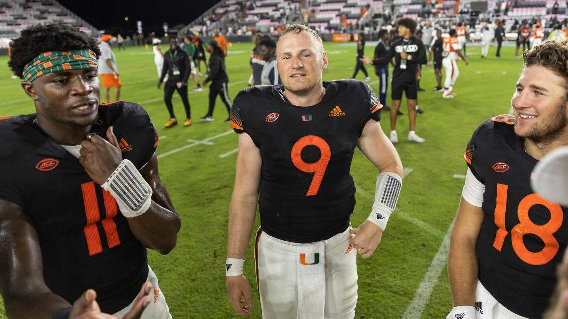 Miami Hurricanes quarterbacks Jacurri Brown (11), Tyler Van Dyke (9) and Aristides Angelo Jr. (18) talk after they finished playing in their spring game at DRV PNK Stadium on Friday, April 14, 2023, in Fort Lauderdale, Fla.