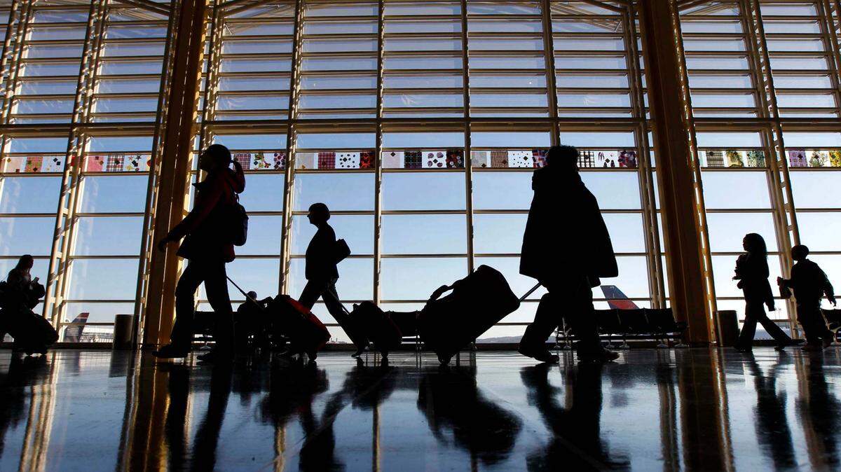 Travelers walk through Ronald Reagan Washington National Airport in November 2010. The CDC recommends that everyone test for COVID-19 before summer travel.