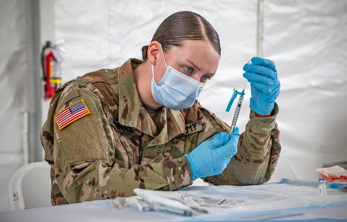 U.S. Army Medic Kristen Rogers prepares a COVID-19 needle for injection during opening day at the FEMA vaccination site on Miami Dade College’s North Campus on Wednesday, March 3, 2021.