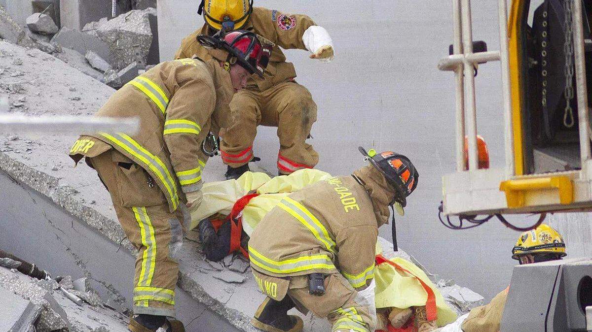 Members of Miami-Dade Fire Rescue remove a victim from the collapsed parking garage at the Miami Dade College West campus in 2012 .