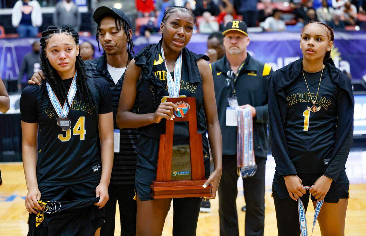 American Heritage’s Dezuray McGill (30) holds the State Runner Up Trophy after Palm Bay wins the FHSAA Class 4A Girls High School Basketball State Championship