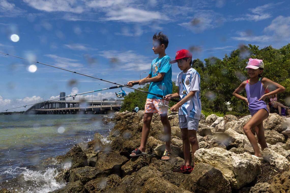 Thomas, 10, Maximo Castro, 8, and Lourdes Cassini, 13, fish from the shore line at Hobie Island Beach on Monday, September 1, 2025, in Key Biscayne, Fla.