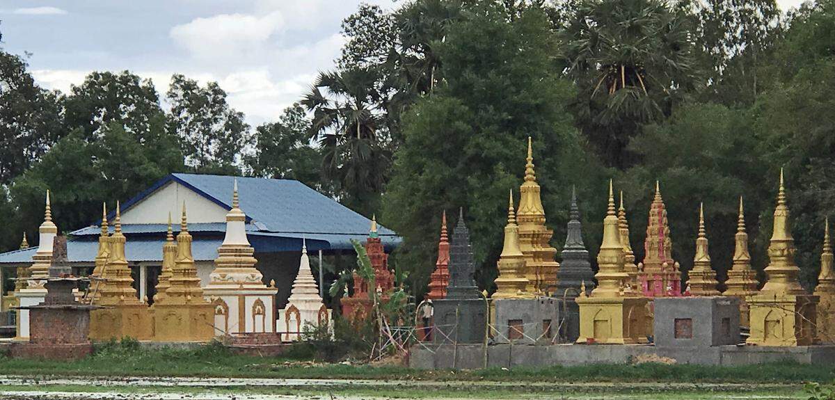 Miniature spires are grave markers, sometimes called stupas or pagodas, in a Cambodian cemetery near a cooking class. 