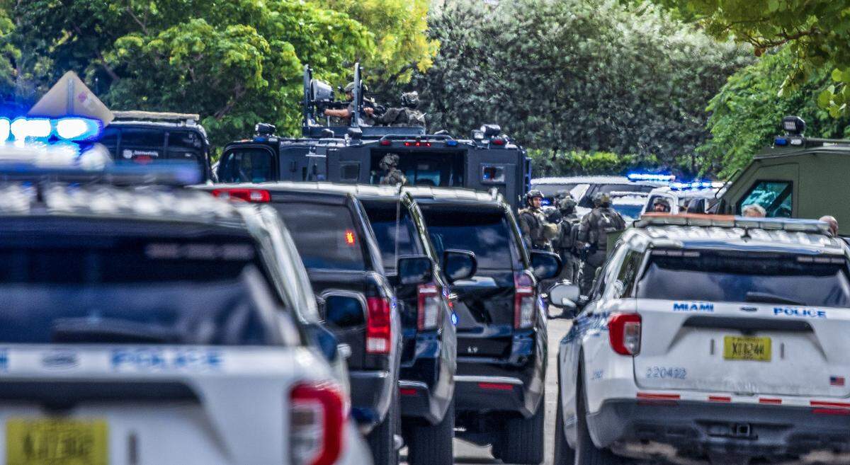 Miami police officers converge near Northwest 26th Street and 16th Avenue after two Miami police officers were shot in Allapattah on Thursday morning, Oct. 9, 2025. An armed man was barricaded inside a house in the area, police said.