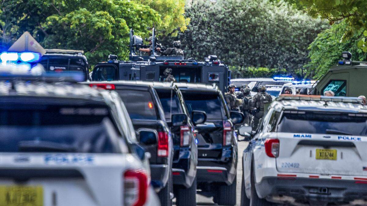 Miami police officers converge near Northwest 26th Street and 16th Avenue as law enforcement responded to a shooting in Allapattah on Thursday morning, Oct. 9, 2025.  Two Miami police officers were shot, and an armed man was barricaded inside a house, Miami police said.