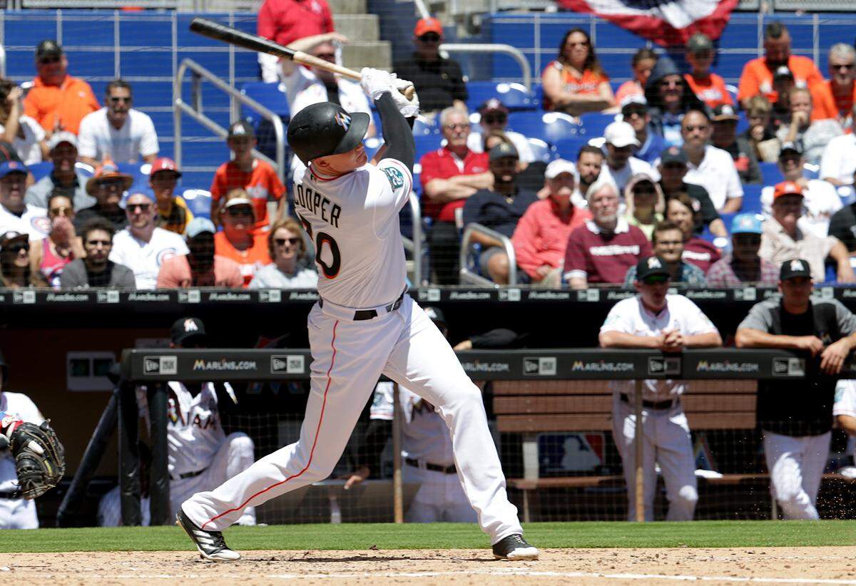 Marlins right fielder Garrett Cooper hits an RBI single during the third inning of the MLB season opener game against the Chicago Cubs on Thursday, March 29, 2018.