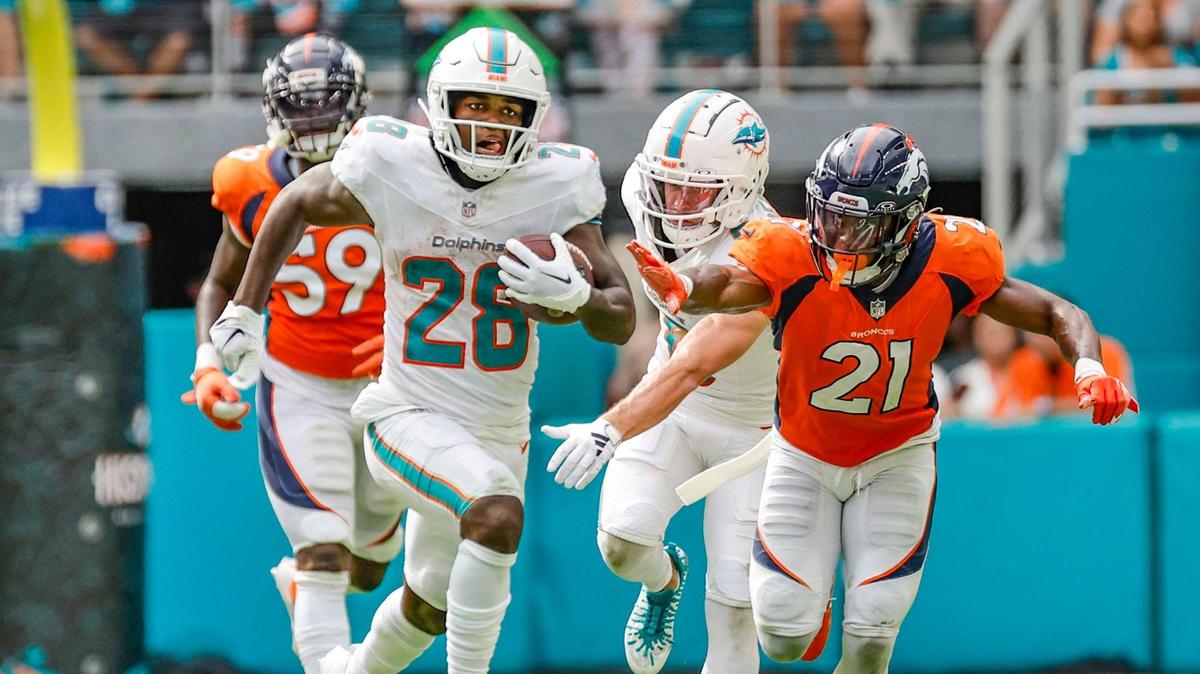 Miami Dolphins running back De’Von Achane (28) gets ahead of the tackle attempt by Denver Broncos cornerback Essang Bassey (21) to score a touchdown in the fourth quarter at Hard Rock Stadium in Miami Gardens on Sunday, September 24, 2023.