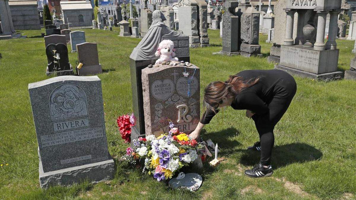 In 2020, Sharon Rivera adjusts flowers at the grave of her daughter, Victoria, at Calvary Cemetery in New York, on Mother’s Day. Victoria died of a drug overdose at 21 years old.